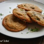 four chocolate chip cookies with thyme on plate
