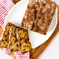 snickerdoodle banana bread loaf on platter with three slices beside it