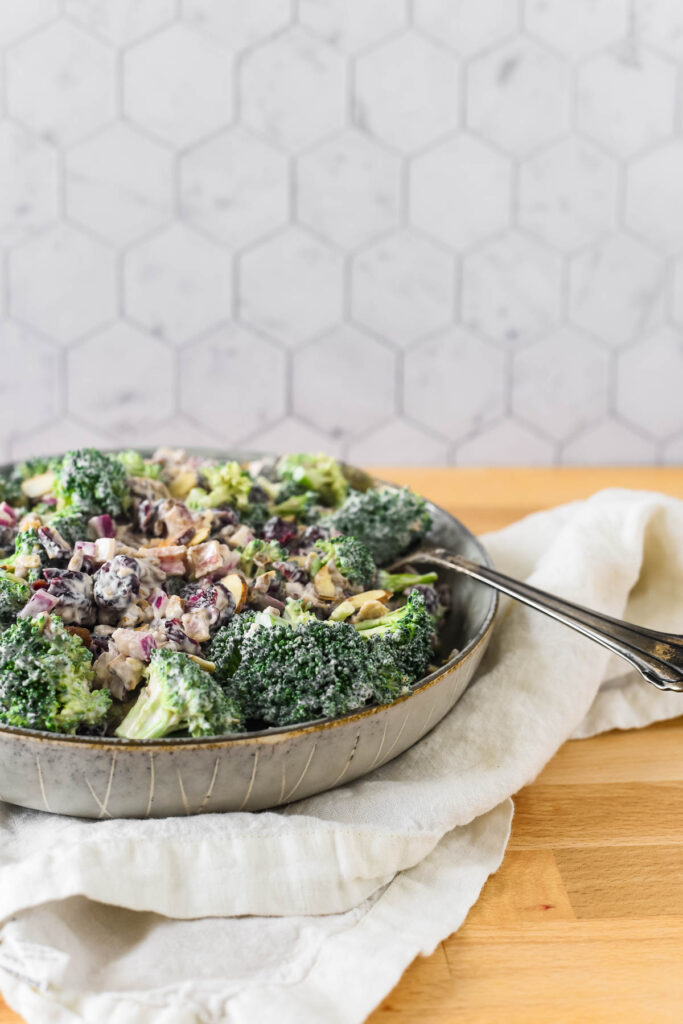serving bowl with broccoli salad and spoon