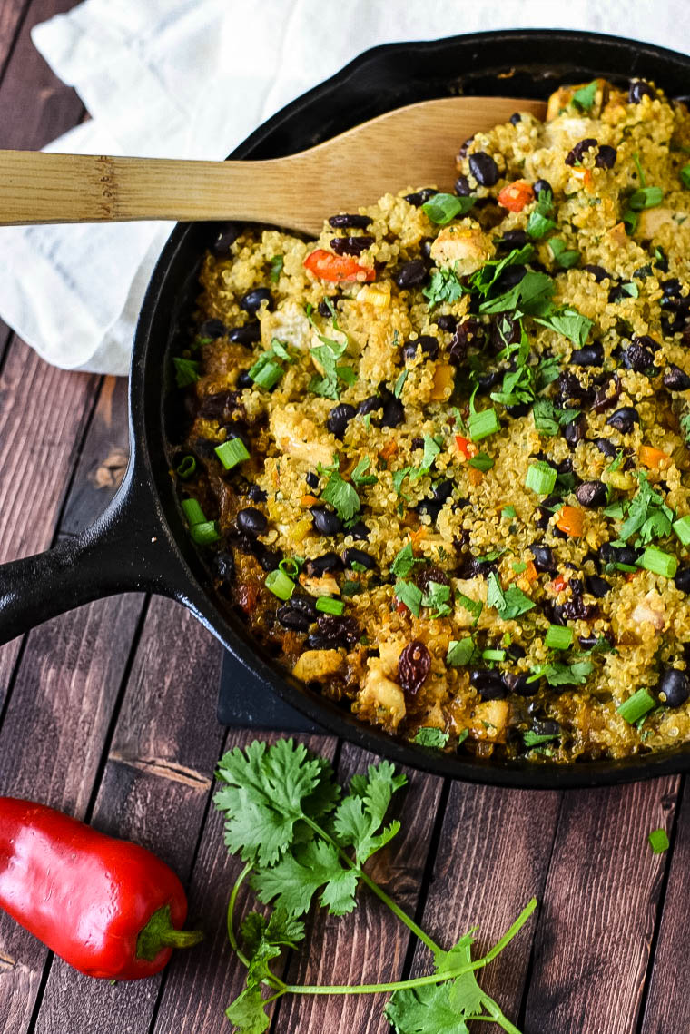 Quinoa Casserole in cast iron skillet with wooden spoon