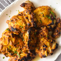 Indian spiced grilled chicken thighs on white platter