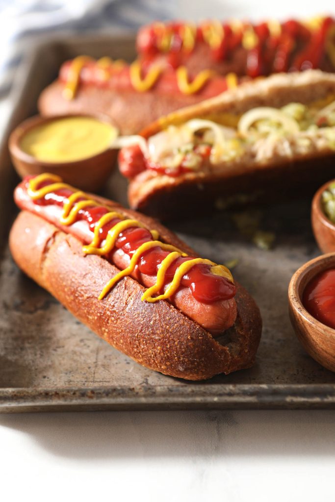 hot dogs in sourdough buns with ketchup and mustard drizzles