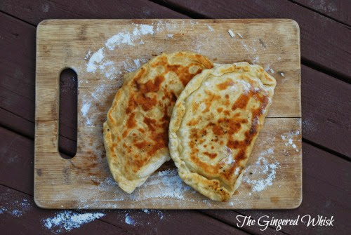 two gozleme with sourdough crust on wooden cutting board