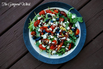 kale salad with blueberries and tomatoes and goat cheese