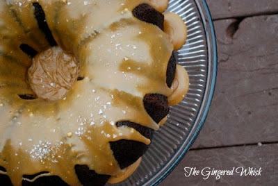 overhead close up of Guinness chocolate cake on glass cake stand with caramel icing and salt flakes