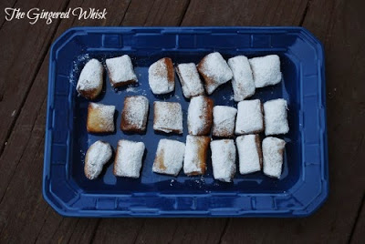 sourdough beignets lined up on blue platter