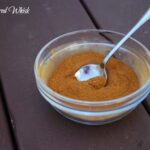 glass bowl filled with cinnabon spice mix, spoon in bowl