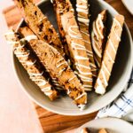bowl of sourdough biscotti with white chocolate drizzle