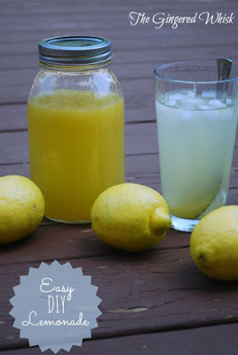 pitcher of lemonade concentrate next to glass with lemons around