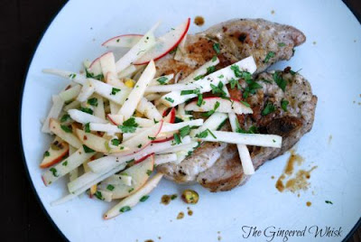 apple kohlrabi slaw on top of pork chops