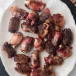 bacon wrapped dates on white platter