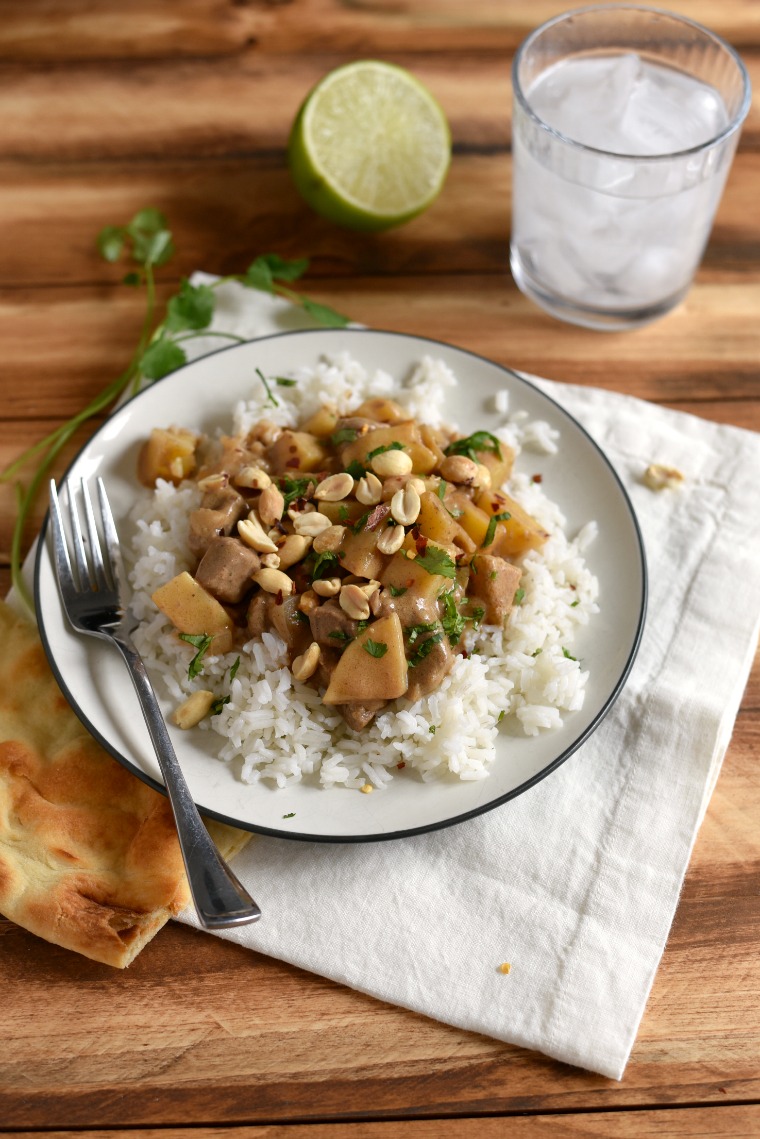 beef curry on rice with fork and naan  beside 