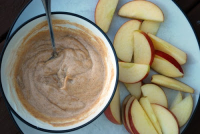 peanut butter apple dip in bowl with sliced apples beside