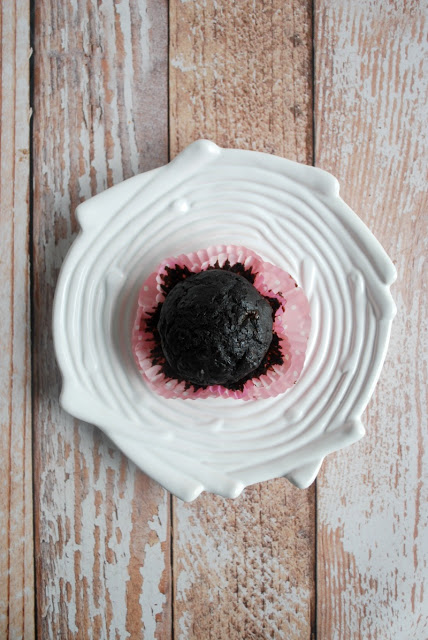 muffin in pink paper sitting on white plate