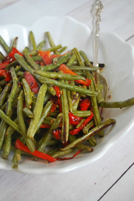 roasted green beans with red peppers in white serving bowl