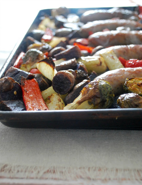 tray with roasted vegetables and brats