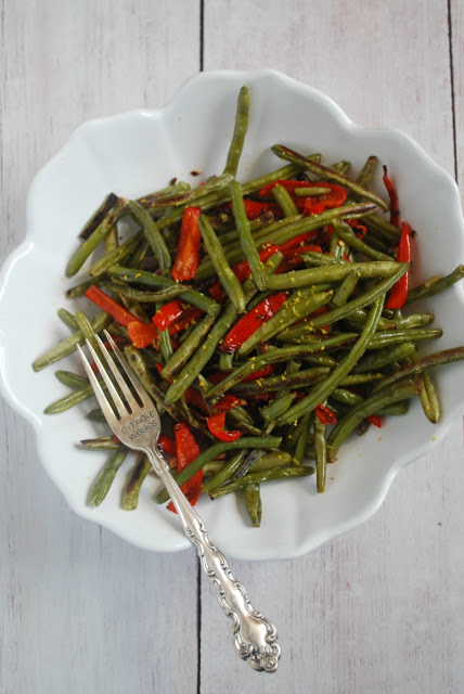 white bowl with green beans and red pepper strips