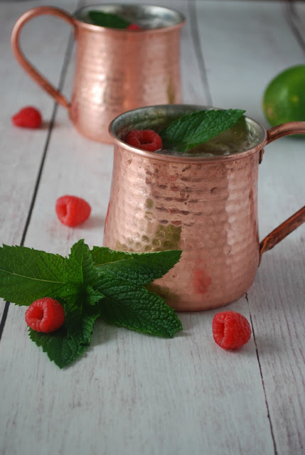 copper mug with mint leaves and raspberries 