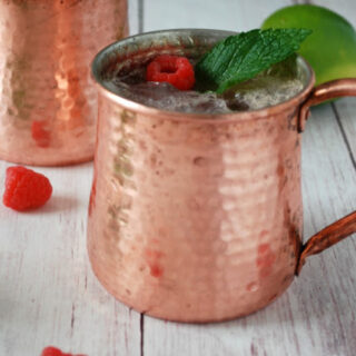 raspberry moscow mule in copper cup with mint leaves