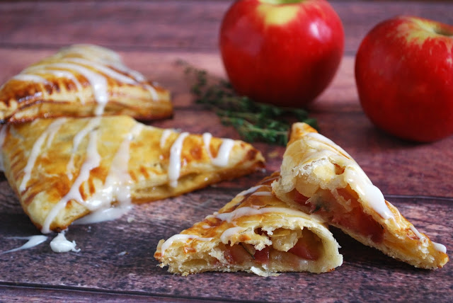 apple turnovers on wooden board with apple behind