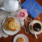 A table set for tea with the book Pride and Prejudice and plates of apple and bacon cheddar scones