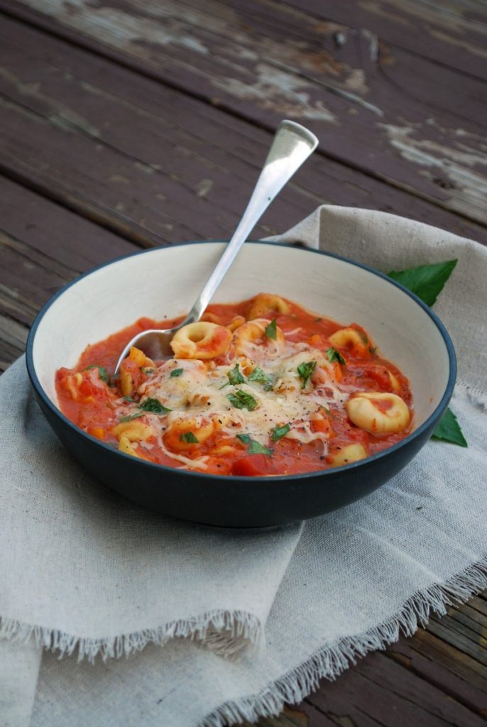 bowl of slow cooker tomato basil soup with cheese tortellini 