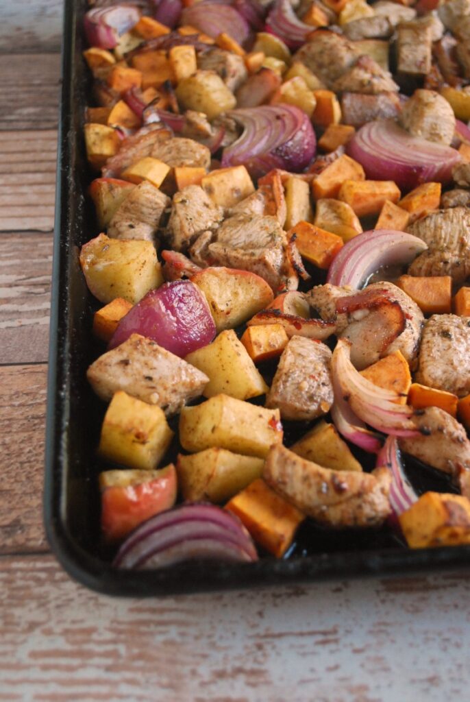 baking tray with diced onions, chicken and sweet potatoes to be roasted