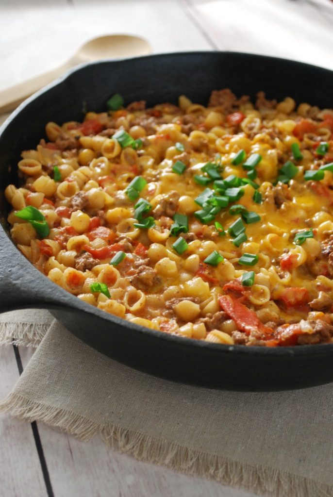A cast iron skillet filled with cheeseburger mac & cheese