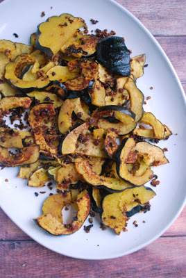 A white platter with roasted acorn squash