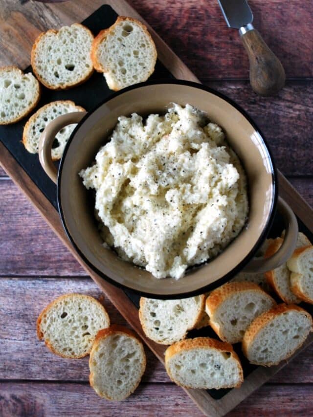 A cheese board with sliced bread and a bowl of cheese dip