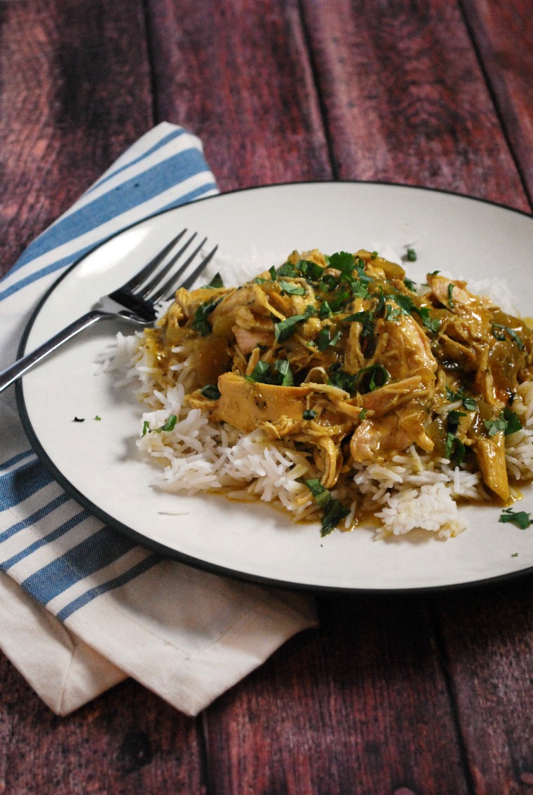 A serving of rice and coconut chicken curry on a white plate with a fork