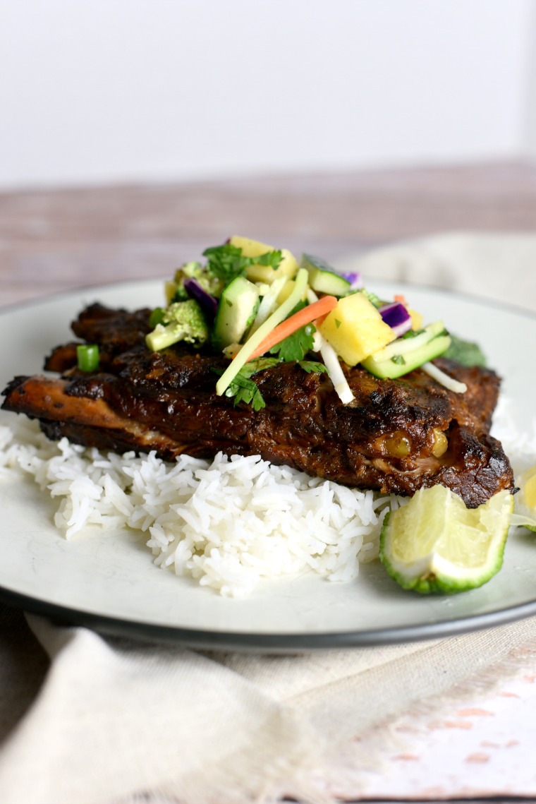 A white plate with rice and Thai turmeric ribs 