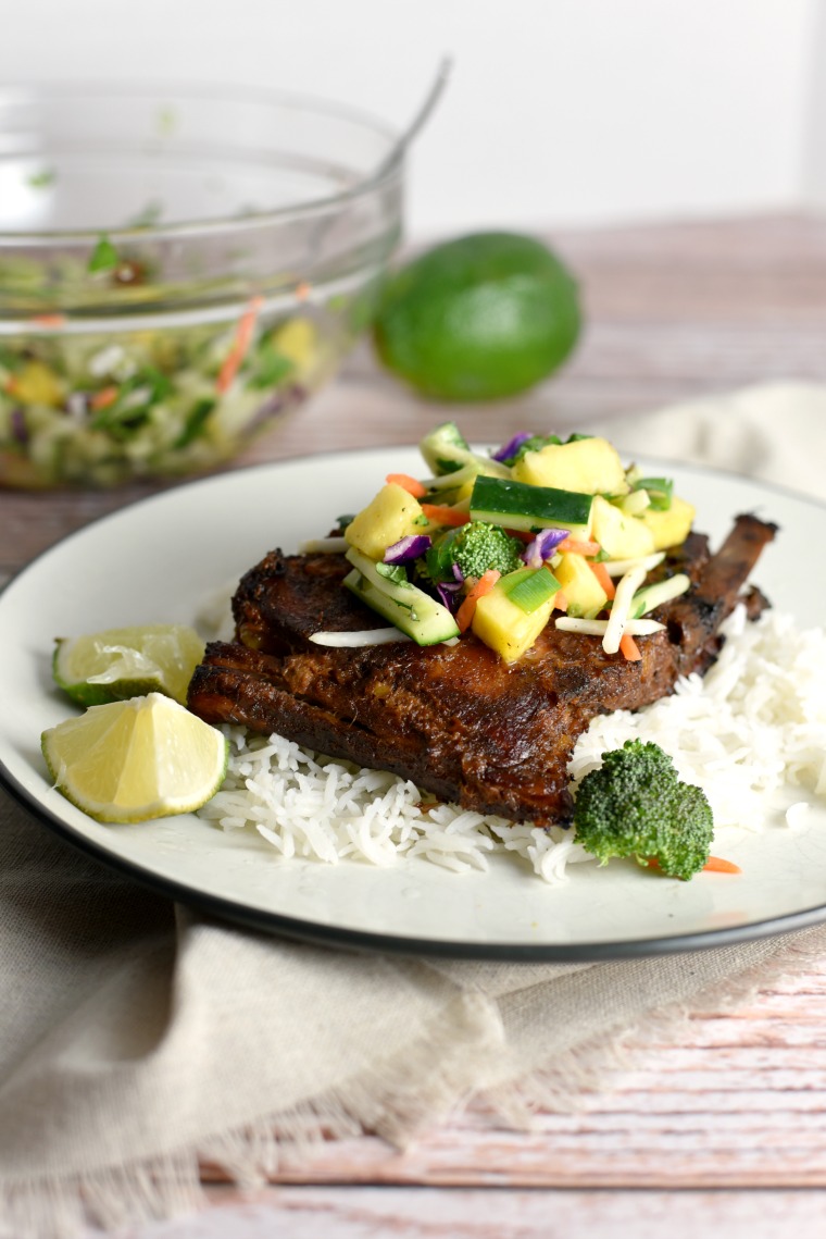 A plate of Thai turmeric ribs and pineapple slaw on a wooden table