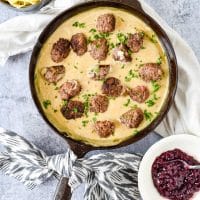 cast iron skillet with homemade swedish meatballs. Bowl of lingonberry jam on the side.