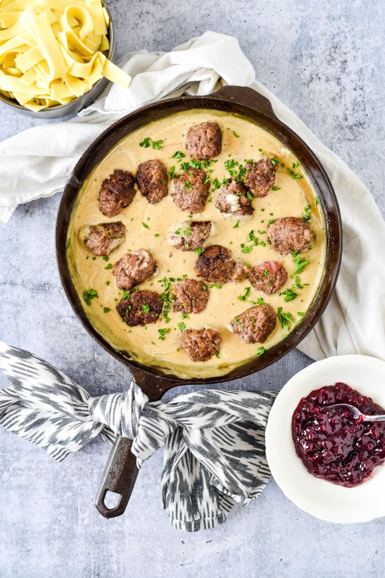 cast iron skillet with homemade swedish meatballs. Bowl of lingonberry jam on the side.