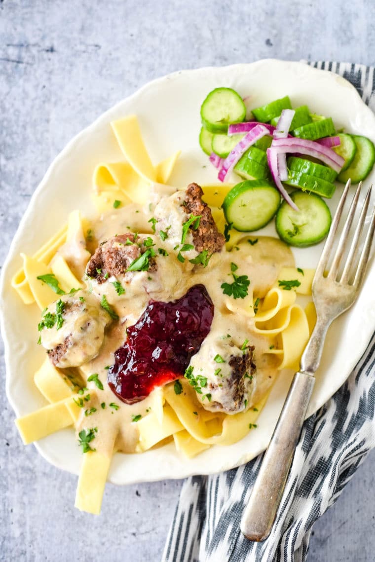 swedish meatballs on plate with noodles and cucumbers