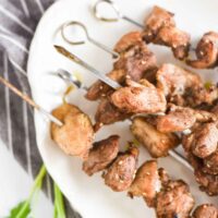 chicken skewers on a white plate