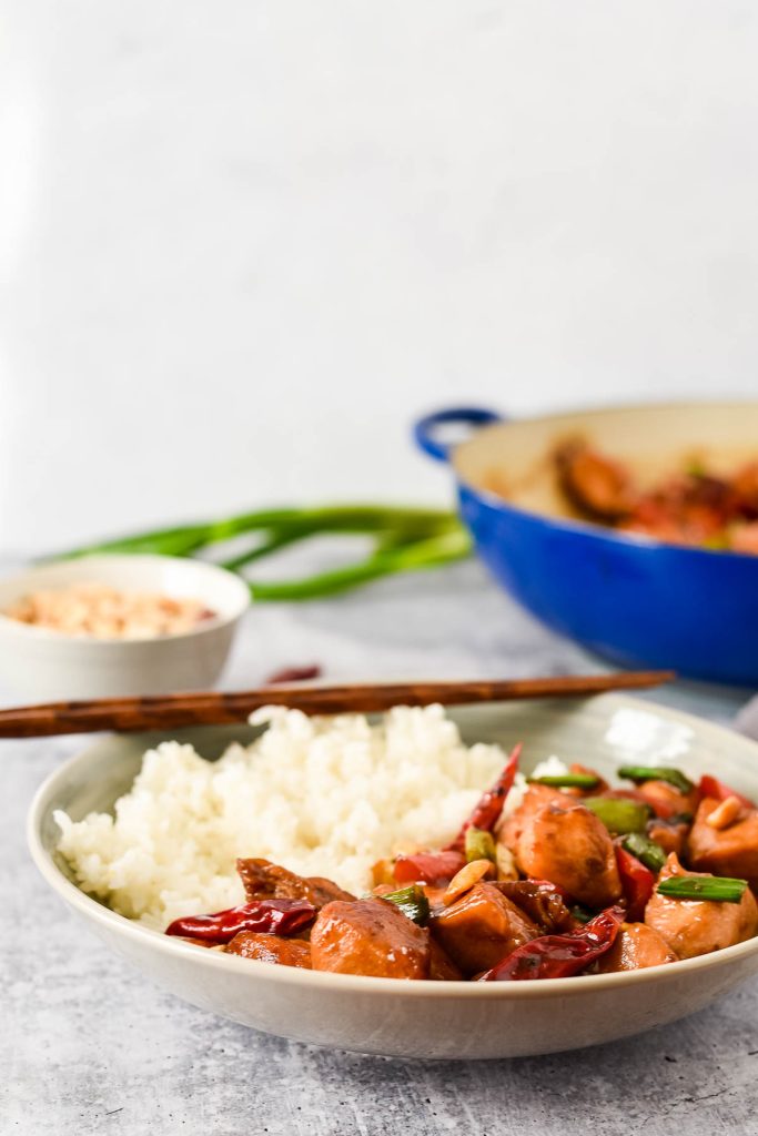 homemade kung pao chicken in bow with rice and chopsticks