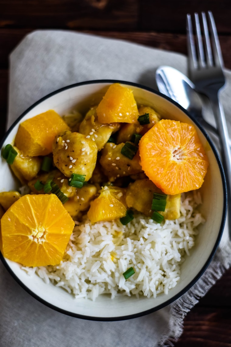 A white bowl of orange chicken with rice