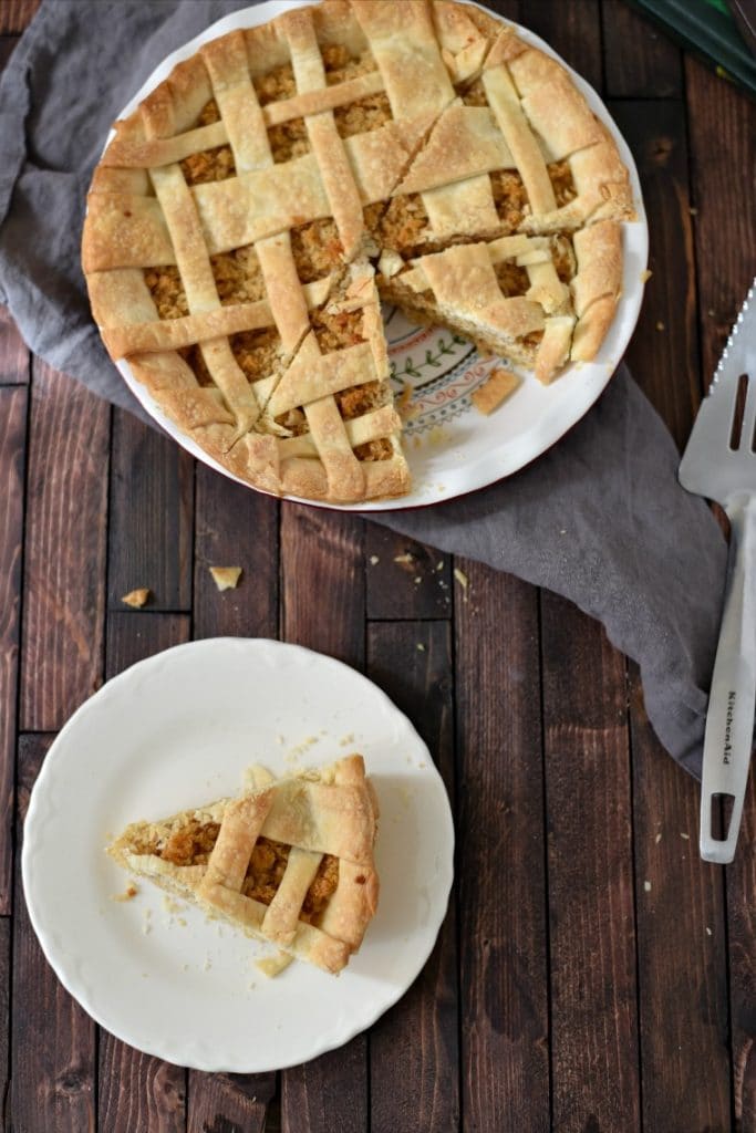 A plate of treacle tart with the whole pie in the background 