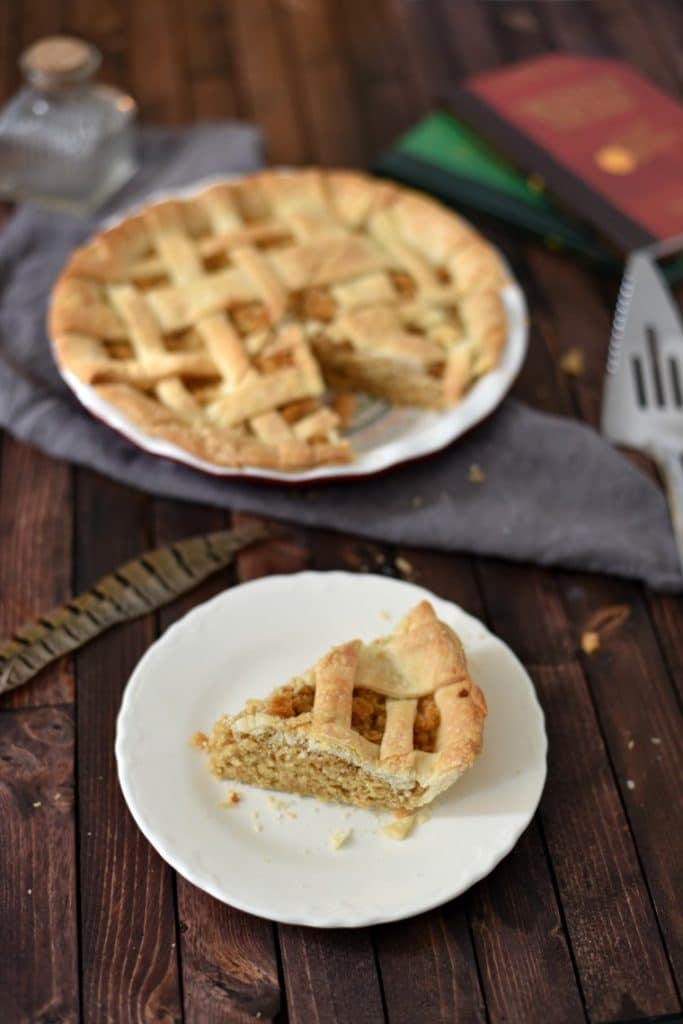 A wooden table topped with plates of Treacle tart