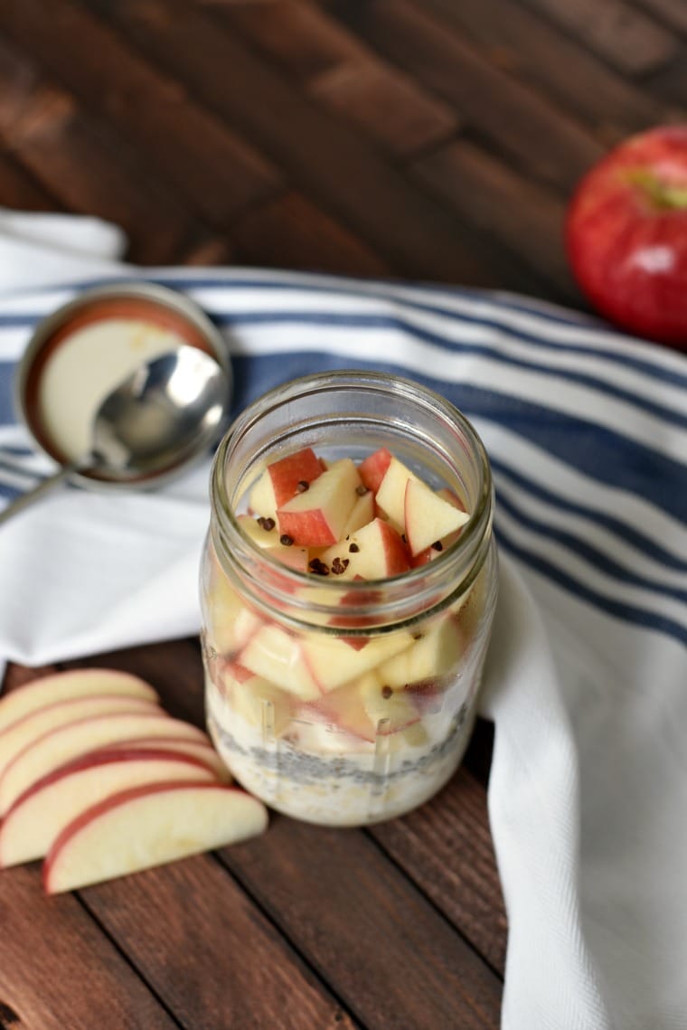mason jar with overnight oats, chopped apples and grains of paradise