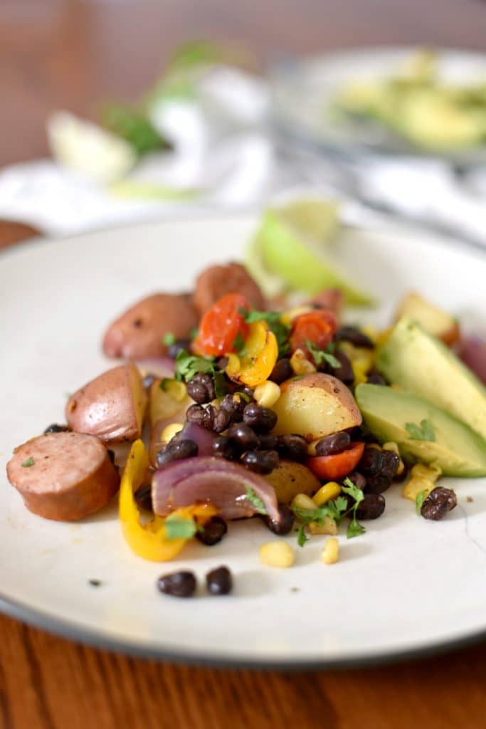 A white plate with sausage sheet pan meal