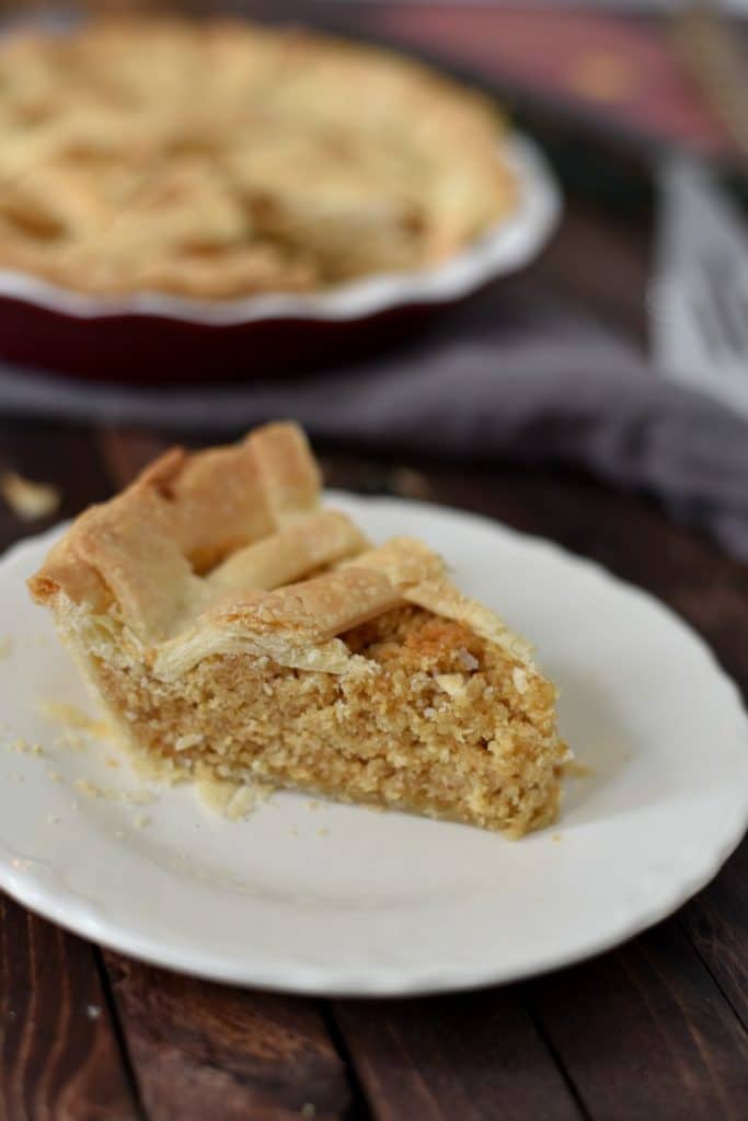 A slice of treacle tart on a white plate