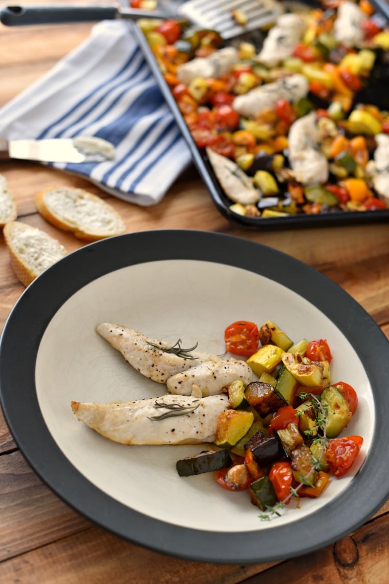 plate with chicken and roasted vegetables with sheet pan behind