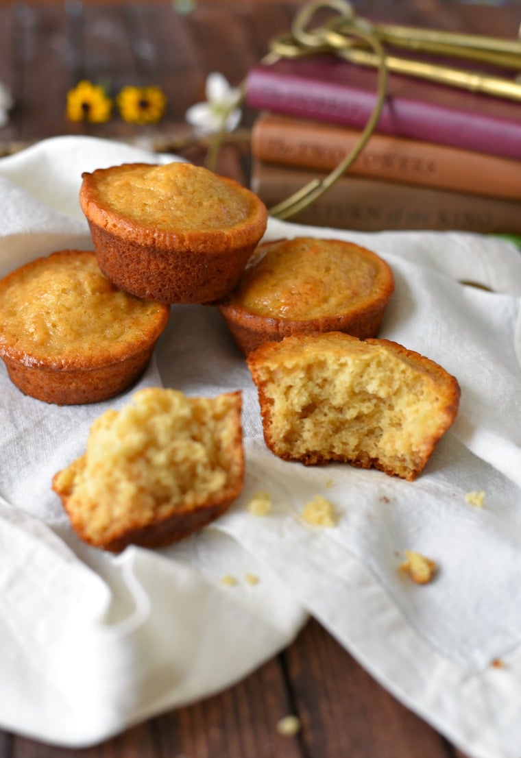 A white towel with four honey cakes on top, one honey cake is split in half