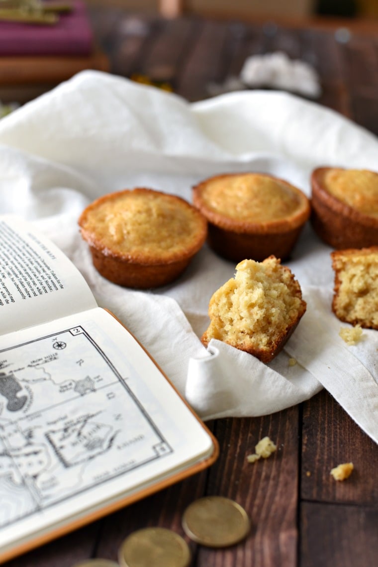 An open book and four honey cakes on top of a white towel 