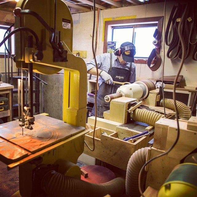 man in work room making wooden spoon