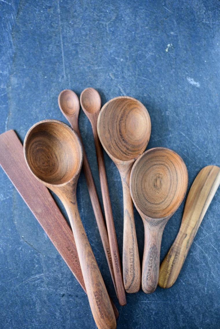 collection of wooden utensils arranged on blue backdrop