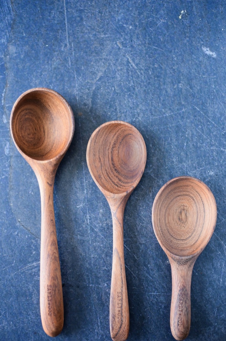 Three wooden spoons on a blue surface